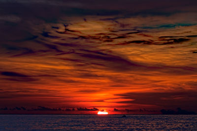 Scenic view of sea against dramatic sky during sunset