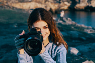 Portrait of young woman photographing