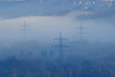 Electricity pylon on land against sky