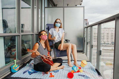 Young lesbian lgbtq women family spending time on balcony. staycation during coronavirus pandemic