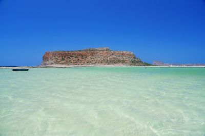 Built structure on beach against clear blue sky