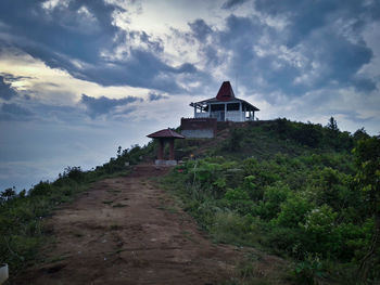 House amidst trees and building against sky