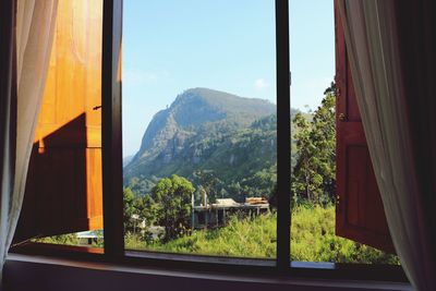 Scenic view of mountains against sky seen through window