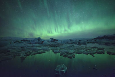 Icebergs in lake against sky at night