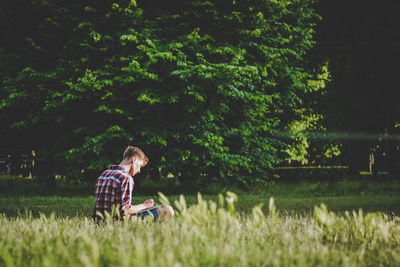 Side view of young man on field