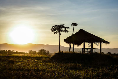 Gazebo on field against sky during sunset