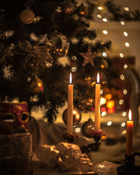 Christmas decor fireplace with candles and  decorated christmas tree with illuminated lights