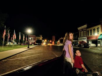 Woman standing on street at night