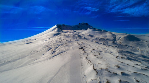 Scenic view of snowcapped mountain against blue sky