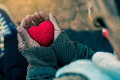 Close-up of hand holding heart shape knitted wool