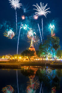 Firework display over lake at night