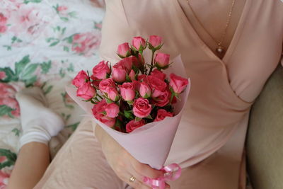 Midsection of woman holding rose bouquet