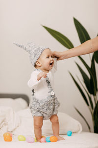 Cropped hand of mother holding baby at home