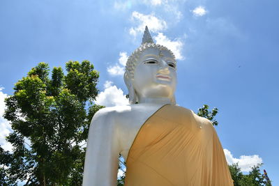 Low angle view of statue against trees against sky