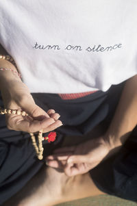 Midsection of woman holding prayer beads