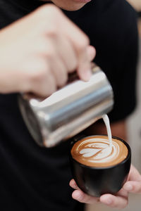 Cropped image of hand holding coffee cup