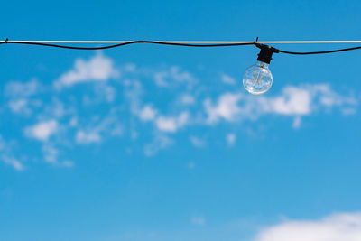 Vintage light bulb with blue sky and white clouds on background. electricity concept. earth hour