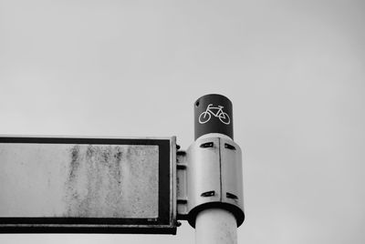 Low angle view of bicycle lane sign against sky