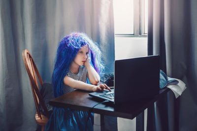 Cute girl using laptop at home