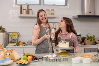 Happy mother and daughter in kitchen at home