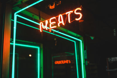 Low angle view of illuminated sign at night