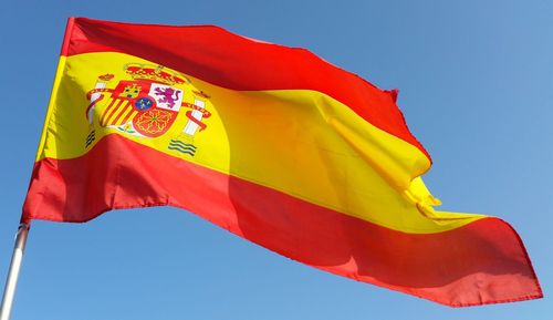 Low angle view of flag waving against blue sky