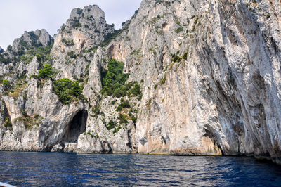 Rock formations by sea against sky