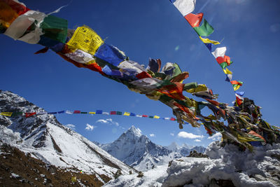 Prayer flags in front of ama dablam's peak on the trail to mt everest.