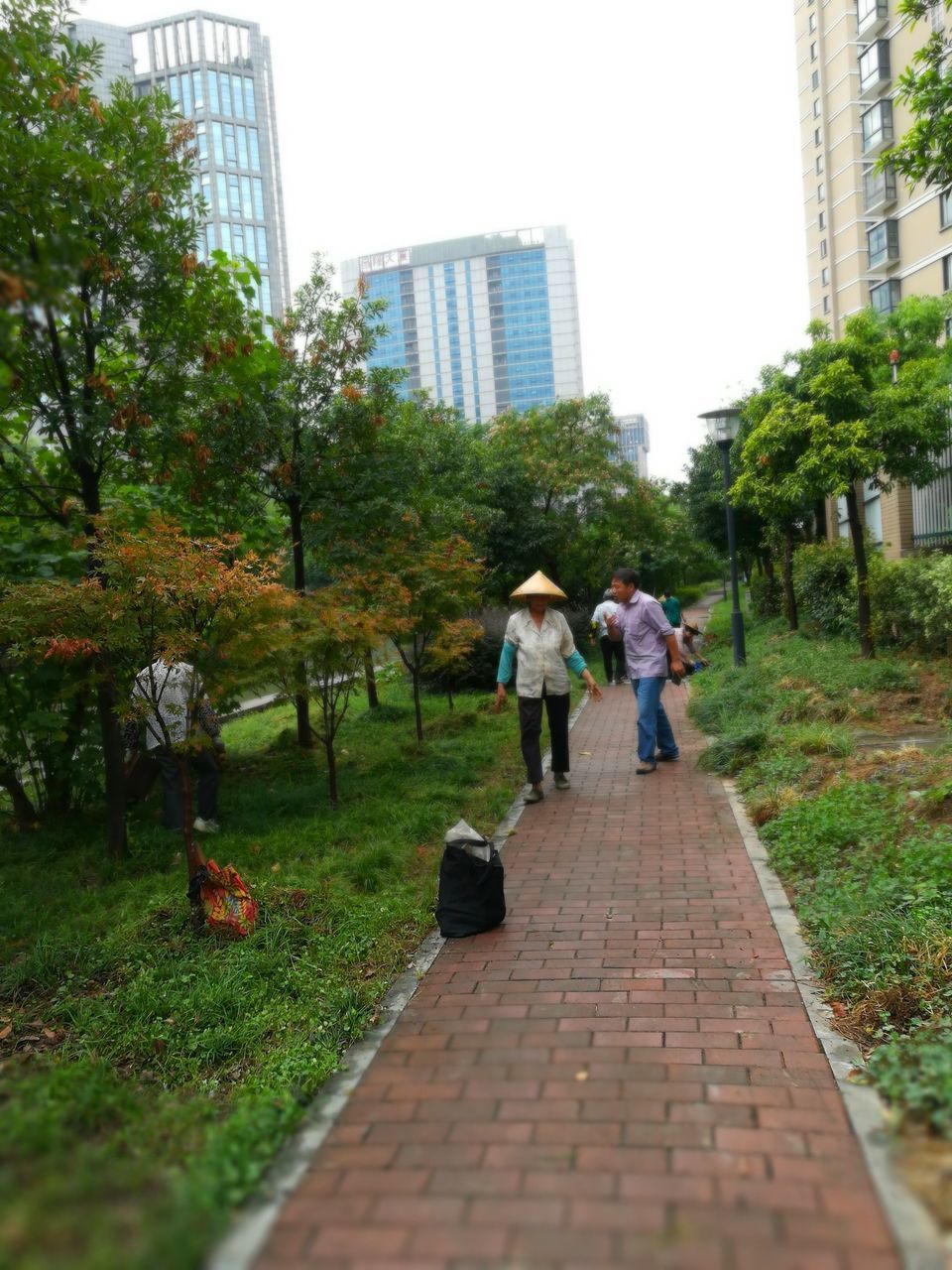 REAR VIEW OF PEOPLE WALKING ON MODERN SKYSCRAPERS