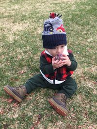 Full length of boy sitting on field