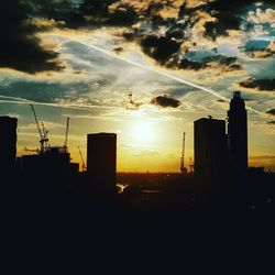 Silhouette buildings against sky during sunset
