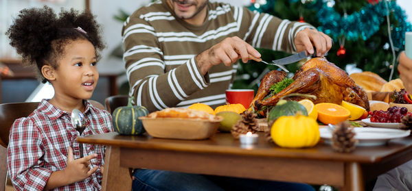 High angle view of people sitting by food on table