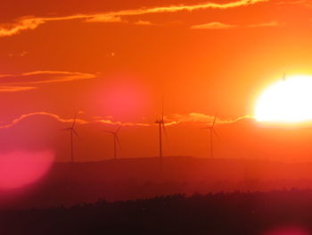 Scenic view of silhouette landscape against orange sky