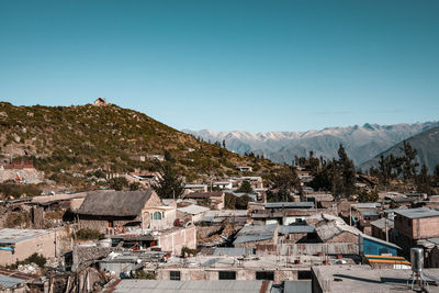 Houses on mountain against clear blue sky