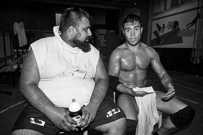 Full length of shirtless man sitting on floor