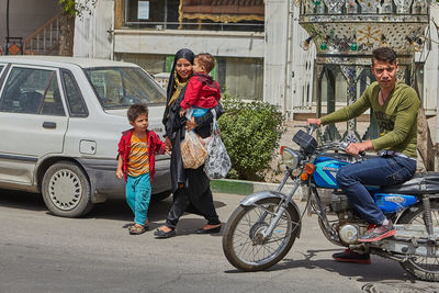 Rear view of people on bicycle in city