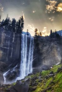 Low angle view of waterfall against sky