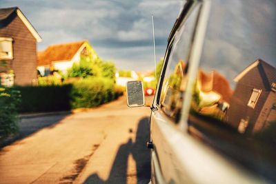 Close-up of car on road against buildings