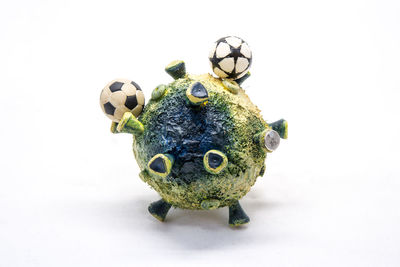 Close-up of frog with ball against white background