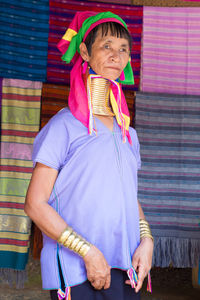 Portrait of woman standing against multi colored umbrella