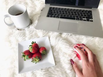 High angle view of hand holding coffee cup on table