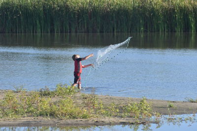 Boy playing at lake