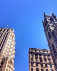 Low angle view of buildings against clear blue sky