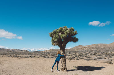 Man standing on desert against blue sky