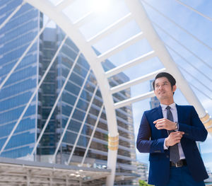 Businessman standing against buildings in city