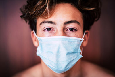 Close-up portrait of teenage boy wearing protective mask