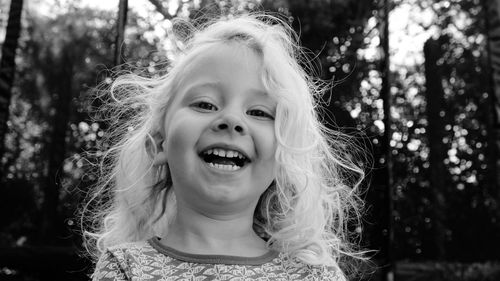 Portrait of smiling girl against trees