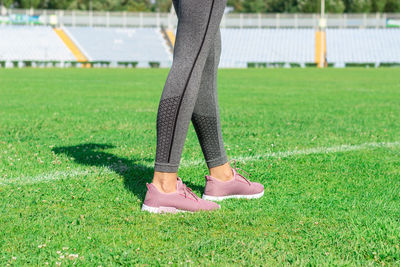 Low section of woman standing on playing field