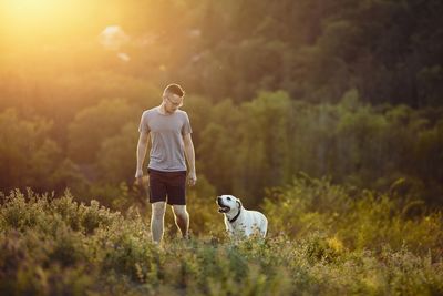 Man with dog standing on field
