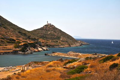 Scenic view of sea and mountains against clear sky